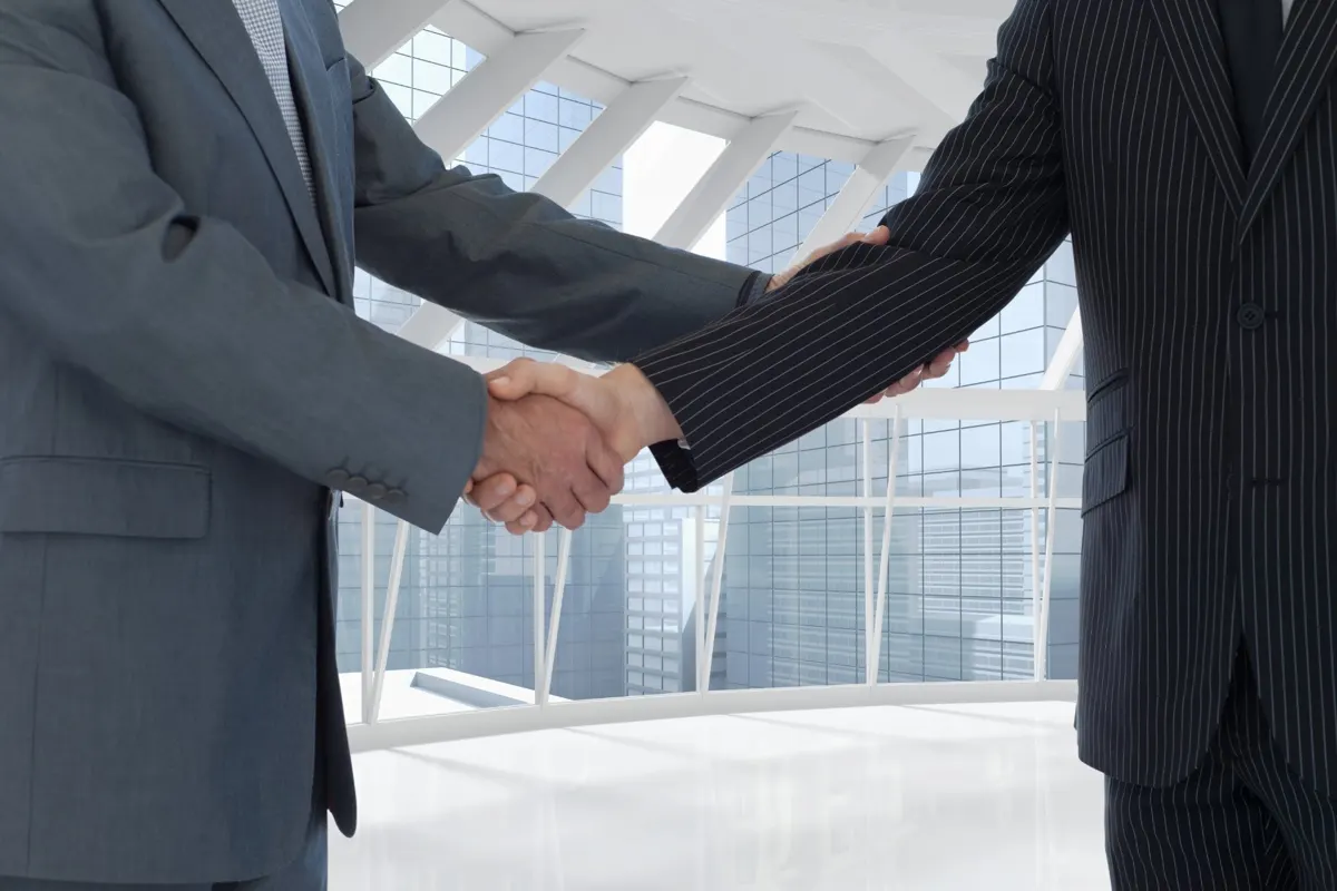 Aperto de mão entre empresários em escritório moderno